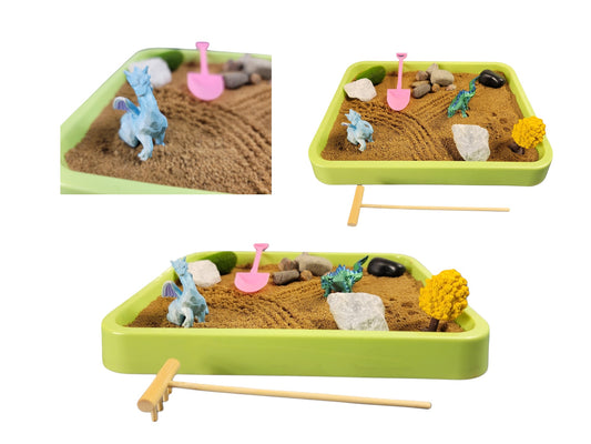 A Dragon Desktop Zen Garden kit with a green tray, sand, dragon figurines, rocks, a tree, and tools for shaping the sand.