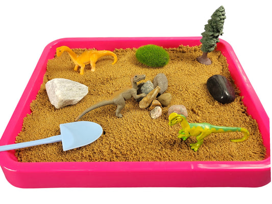 A dinosaur-themed desktop zen garden  in a magenta tray with sand, various stones, miniature dinosaur figurines, a tree, and a moss rock.