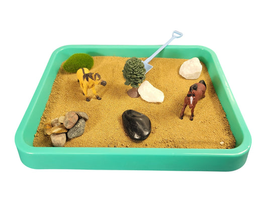 A Horse Desktop Zen Garden with a teal tray containing sand, horse figurines, rocks, and a tree. 